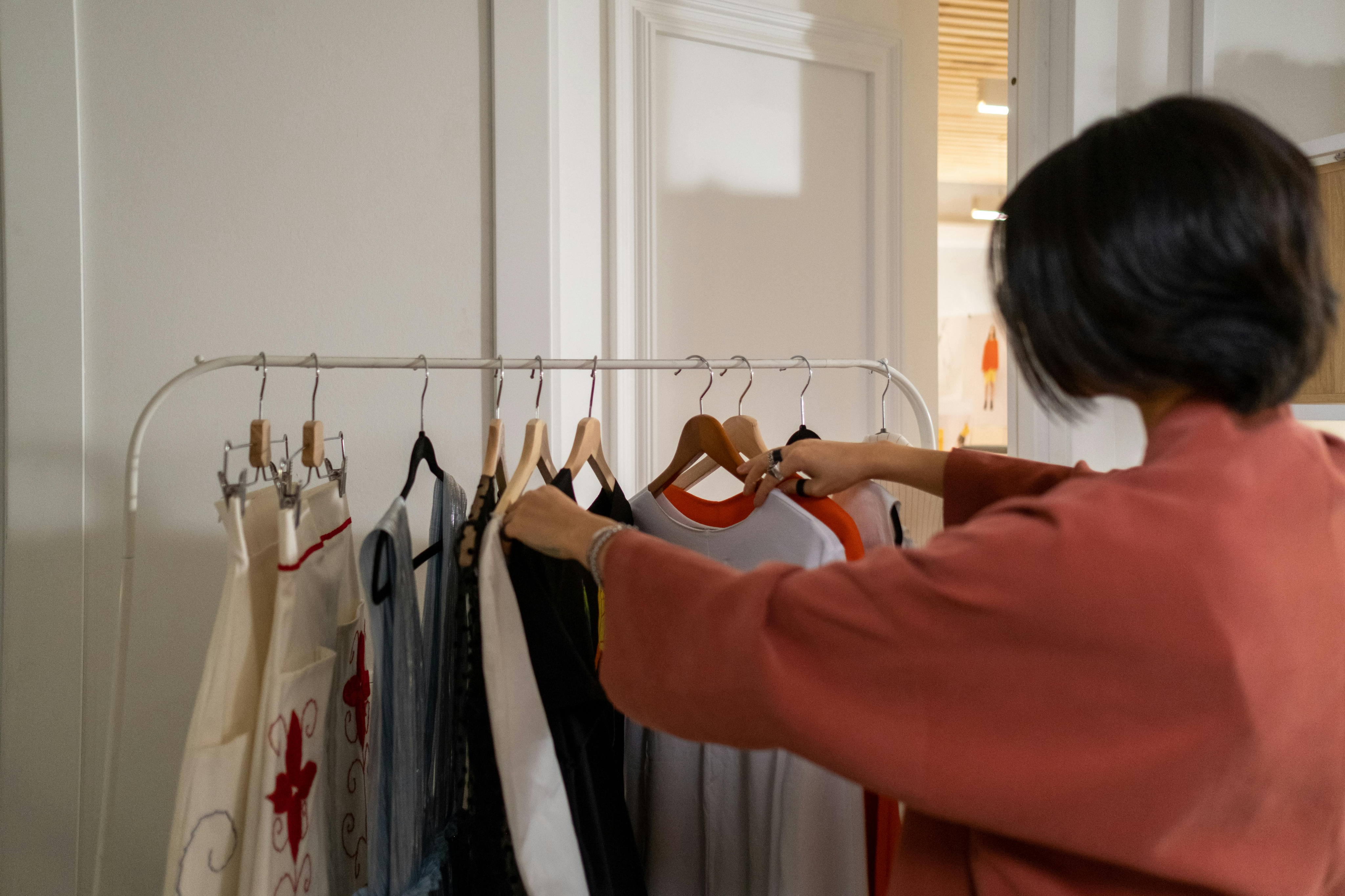 Woman sorting through clothes on clothes rack